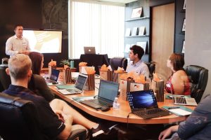 Business professionals reviewing compliance documents at a conference table in a modern corporate office