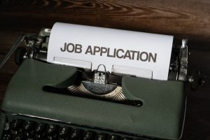 Person reviewing job applications on a laptop, representing AI-assisted recruitment and hiring technology